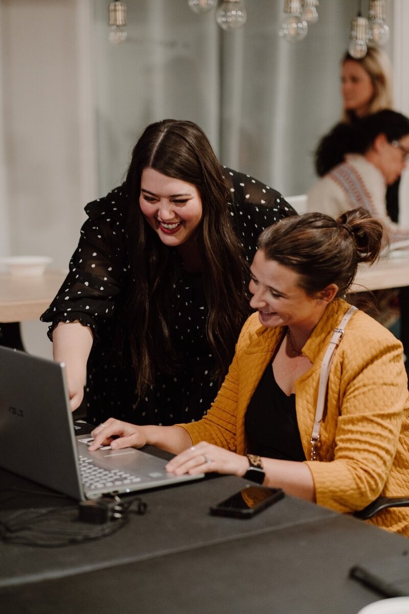 A workshop attendee getting hands-on help at a laptop during a TK Creative session